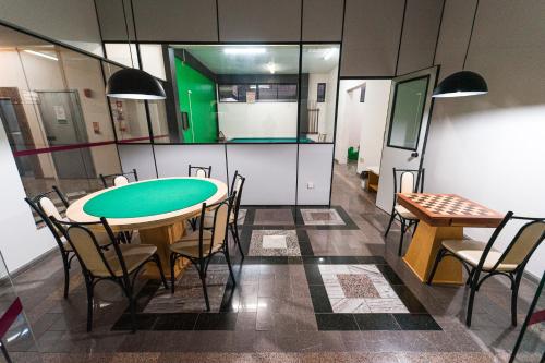 a conference room with a green table and chairs at Condall Palace Hotel in Nova Prata