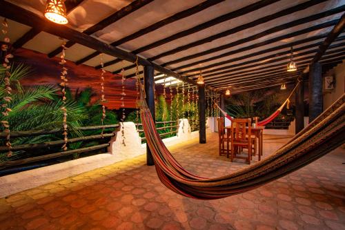 a hammock in a porch with a table and chairs at Playa El YAQUE Posada Yaque Sol, Isla de Margarita in El Yaque