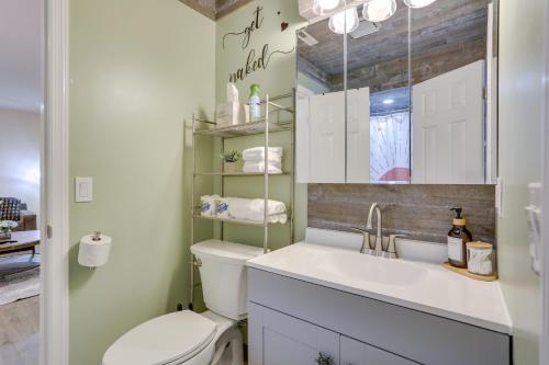 a bathroom with a toilet and a sink and a mirror at Modern Vernon Township Condo Near Ski and Water Park in Vernon Township