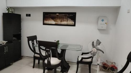 Zimmer mit einem Tisch, Stühlen und einem Ventilator in der Unterkunft Hotel Bellagio in Barrancabermeja