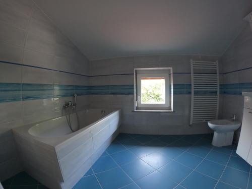 a bathroom with a white tub and a sink at Attic apartment with a terrace in Sežana