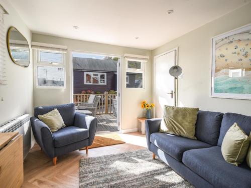 a living room with a blue couch and two chairs at Marnie's Rest in Lyme Regis
