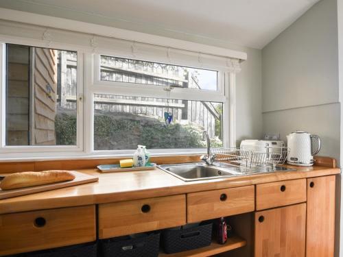 a kitchen with a sink and a window at Marnie's Rest in Lyme Regis