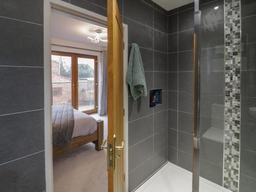 ein Bad mit ebenerdiger Dusche neben einem Schlafzimmer in der Unterkunft 85A Braybrooke Road in Kettering