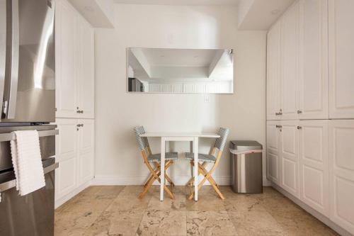 uma cozinha branca com uma mesa e 2 cadeiras em KEY BISCAYNE BEACH VACATION #3 em Miami