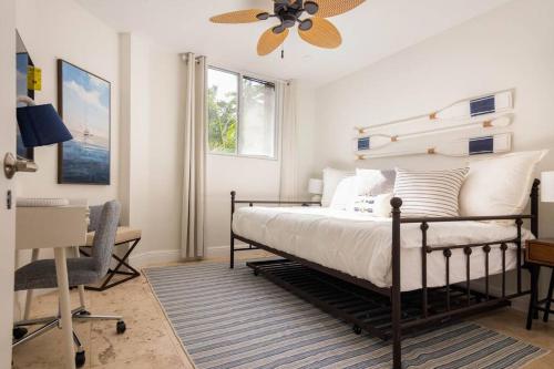 邁阿密的住宿－KEY BISCAYNE BEACH VACATION #3，一间卧室配有一张带吊扇的床和一张书桌。