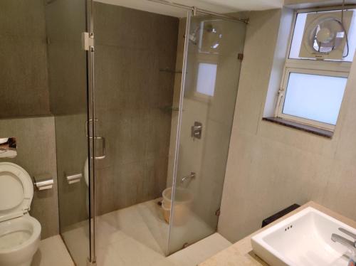 een badkamer met een douche, een toilet en een wastafel bij Eternal Wave Apartments by Daystar Ventures in Calangute