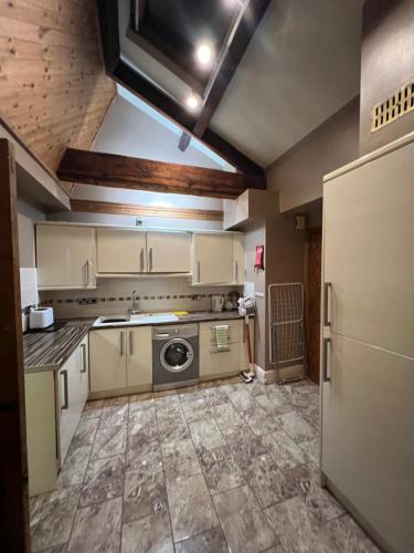 a kitchen with a washer and dryer in it at Stackhouse flat in Burnley
