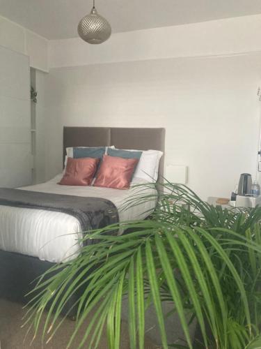 1 dormitorio con 1 cama con 2 almohadas y planta en The Esplanade, en Weymouth