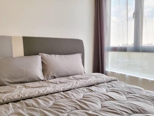 an unmade bed in a bedroom with a window at D'Summit Tropika - 2 Rooms 4 Pax, Free Parking in Johor Bahru