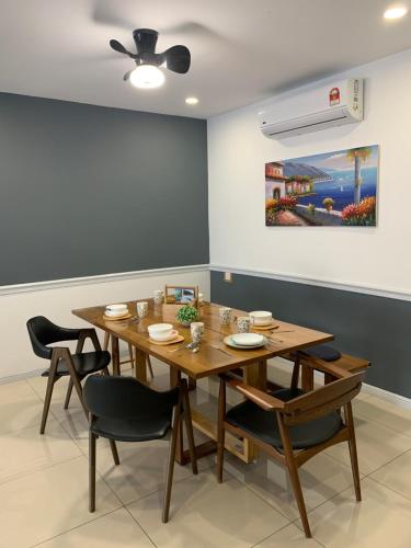 a dining room with a wooden table and chairs at Ipoh Homestay - Manhattan Condominium with Water Park & Leisure Facilities in Ipoh