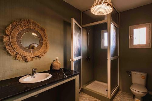 een badkamer met een wastafel, een toilet en een spiegel bij Central Majorelle Apartment Sleeps 4 in Marrakesh