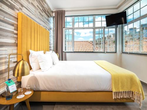 a bedroom with a bed and a large window at Casa Senhoras Rainhas - Óbidos - by Unlock Hotels in Óbidos