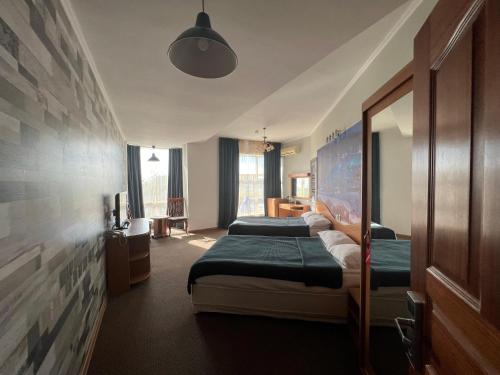 um quarto com 2 camas e um espelho em Three Dolphins Hotel em Aktau