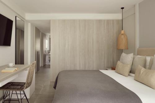 a bedroom with a bed and a desk and a table and chair at Mare Paphos in Paphos