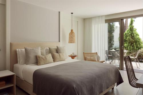 a bedroom with a large bed and a balcony at Mare Paphos in Paphos