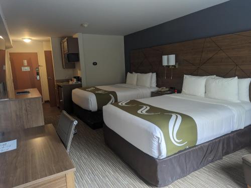 a hotel room with two beds and a television at Quality Inn & Suites Northampton - Amherst in Northampton