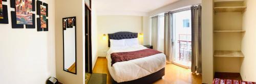 um pequeno quarto com uma cama e uma grande janela em ANDEAN VALLEY HOTEL em Cusco