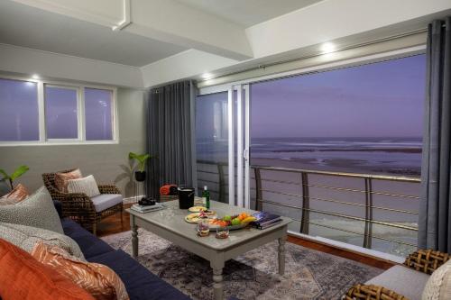 een woonkamer met uitzicht op de oceaan bij Cape Recife Lighthouse Luxury Villa in Port Elizabeth