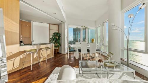 a living room with a table and chairs and a kitchen at Luxurious 4 BR Penthouse in NYC in New York