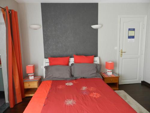 a bedroom with a red bed with red pillows at Aux Portes de Rennes Ch. d'hôtes in Chartres-de-Bretagne