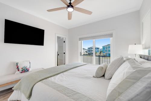 een witte slaapkamer met een groot bed en een flatscreen-tv bij Playin' Hooky Too in Ocean Isle Beach