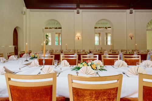 a room with a long table with candles and flowers on it at Waldhotel Forsthaus Hainholz in Pritzwalk