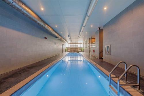 a large swimming pool with blue water in a building at Stylish 2 Bedrooms Condo w/ awesome View & Parking in Toronto