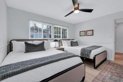 ein Schlafzimmer mit zwei Betten und einem Deckenventilator in der Unterkunft Serene Pool & Spa Home near Beaches & Downtown in Fort Myers