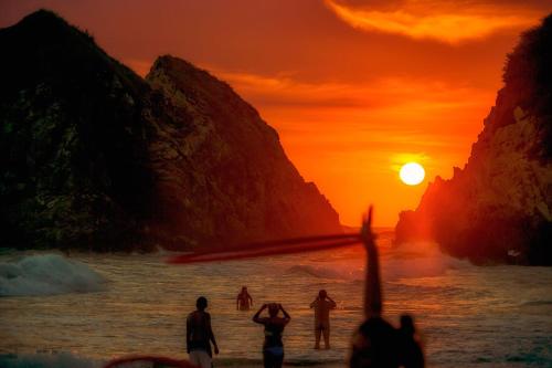 a painting of people on the beach at sunset at El Alquimista Yoga Spa in Zipolite