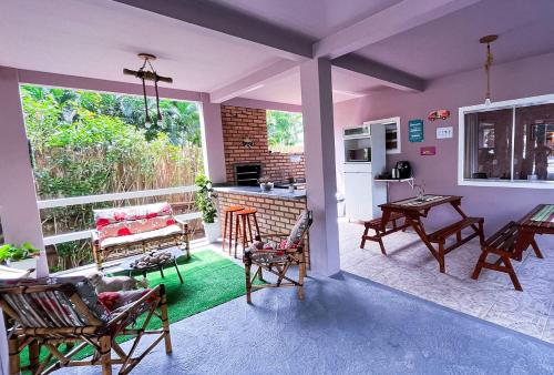 a living room with chairs and a table and a kitchen at Pousada Águas do Embaú in Guarda do Embaú