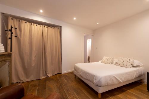 une chambre avec un lit blanc et une fenêtre dans l'établissement Les Appartements du Roi de Rome - Hypercentre Ajaccio, à Ajaccio