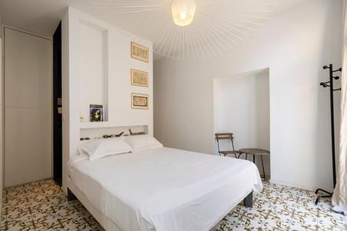 - une chambre avec un lit blanc et un lustre dans l'établissement Les Appartements du Roi de Rome - Hypercentre Ajaccio, à Ajaccio