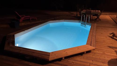 une grande piscine sur une terrasse en bois dans l'établissement La Belle Chaumière, à Bretagne-de-Marsan