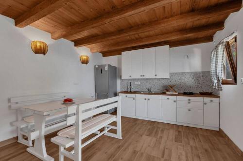 スチュライにあるHoliday Home -Didinaのキッチン(白いキャビネット、テーブル、冷蔵庫付)