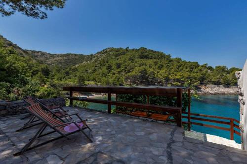 a couple of chairs sitting on a patio next to the water at Holiday Home -Didina in Sućuraj