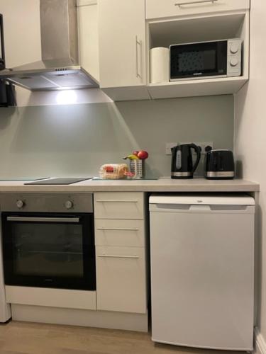 a kitchen with a stove and a microwave at The South Kensington Apartments in London
