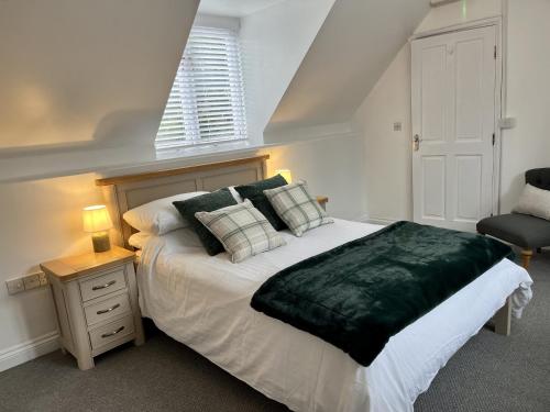 a bedroom with a large bed and a chair at The Coach House - with hot tub in St Austell