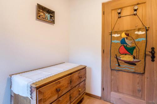 a room with a wooden dresser and a painting on the wall at Ronacherhof Apt Kamille in Auna di Sopra