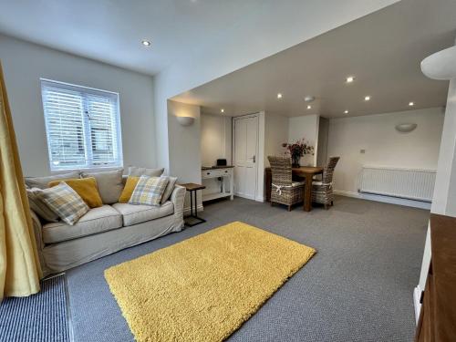 un soggiorno con un divano e un tavolo di The Coach House - with hot tub a St Austell