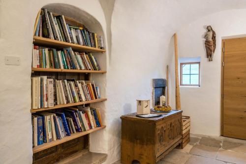 a room with a book shelf filled with books at Ronacherhof Apt Kamille in Auna di Sopra