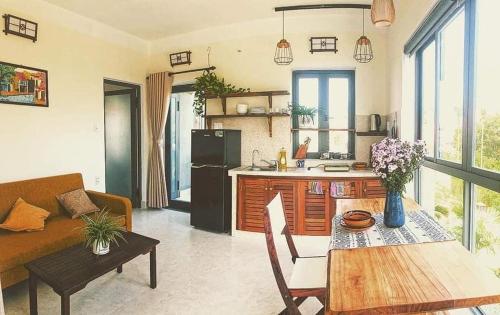a kitchen and living room with a table and a couch at De Mai’s apartment in Hoi An