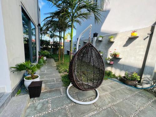 a basket swing sitting outside of a house at De Mai’s apartment in Hoi An