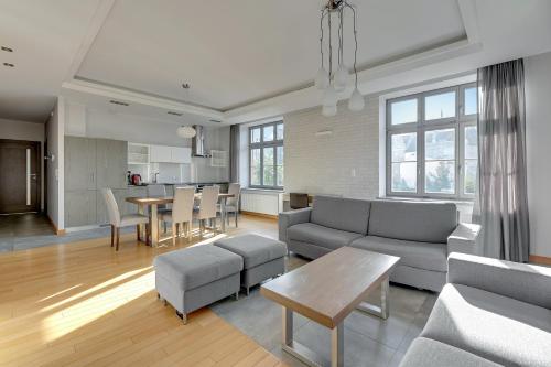 un soggiorno con divano e tavolo di Dom & House Apartments - Old Town Tobiasz Residence - Fitness & Parking a Danzica