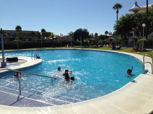 un grupo de personas nadando en una piscina en Appart T3 à louer en Andalousie en Chiclana de la Frontera