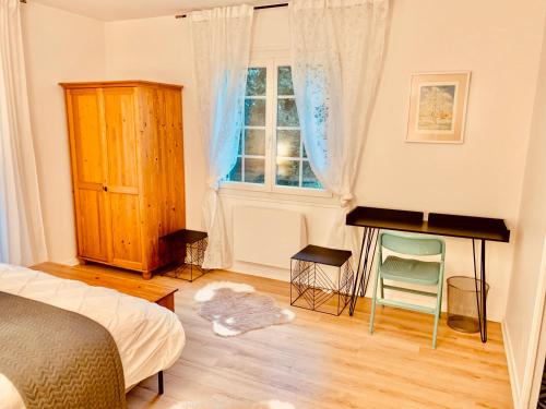 a bedroom with a bed and a desk and a window at Parc de BUC in Buc