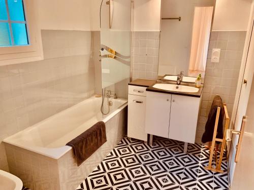 een badkamer met een wit bad en een wastafel bij Parc de BUC in Buc