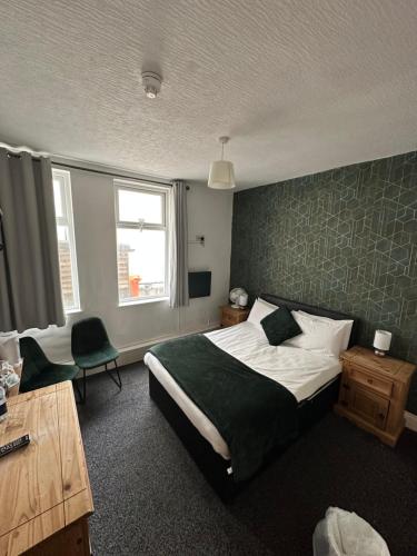 a bedroom with a bed and a desk and a window at North Ocean Hotel in Blackpool