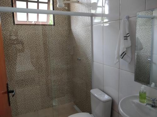 ein Bad mit einer Dusche, einem WC und einem Waschbecken in der Unterkunft Rancho do Capitão Boiçucanga in São Sebastião