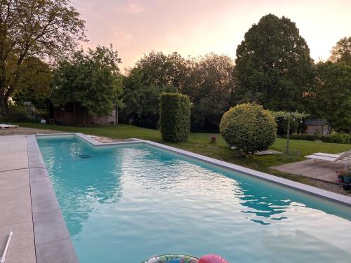 a large blue swimming pool in a yard at Gite MontBleu - 2 holiday houses - La Laiterie & La Grange in Sprimont